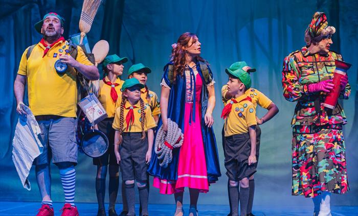 Eight performers on stage in a pantomime.